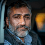 Muhammad Ackas in his vehicle looking into the camera